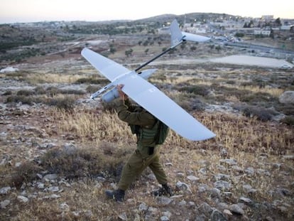 Un soldado este s&aacute;bado cerca de Hebr&oacute;n con un drone usado en el rastreo. 