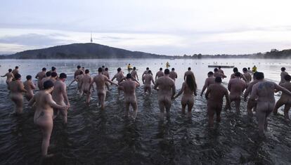 Dezenas de pessoas participam nuas nesta quinta-feira do banho de caridade pelo solstício de inverno no lago Burley Griffin, em Canberra (Austrália). 