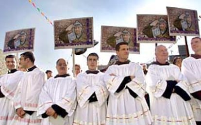 Carteles a favor de Arafat junto a un grupo de religiosos católicos durante una procesión en Belén.