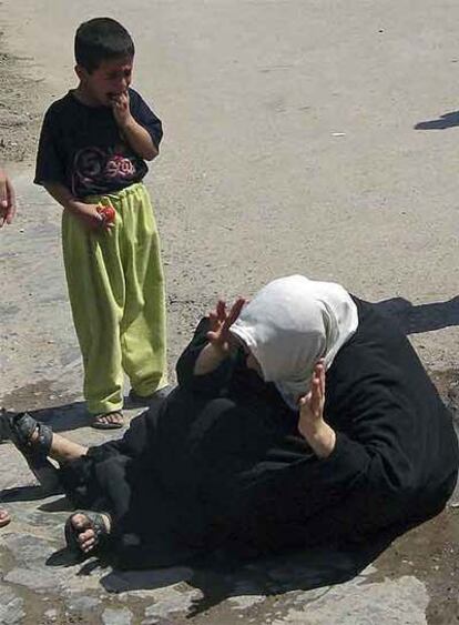 Una mujer y su hijo lloran por la muerte de un familiar en un ataque en Mahmudiya.