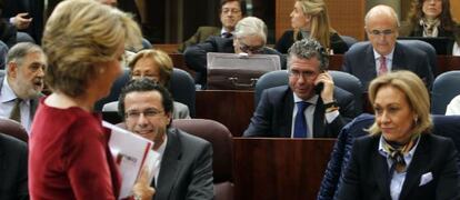 Esperanza Aguirre se dirige ayer a su esca&ntilde;o en la Asamblea de Madrid. En el centro, hablando por el m&oacute;vil, Francisco Granados.