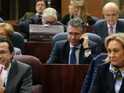 Esperanza Aguirre se dirige ayer a su esca&ntilde;o en la Asamblea de Madrid. En el centro, hablando por el m&oacute;vil, Francisco Granados.