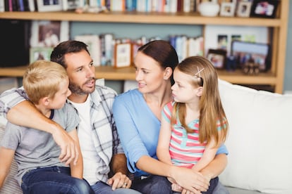 Una familia charla relajada en el sillón.