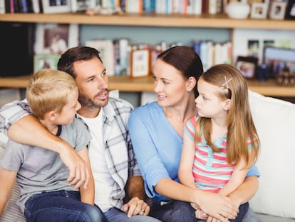 Una familia charla relajada en el sillón.