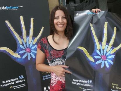 Carmen Ubago, diseñadora gráfica y autora de la imagen ganadora, posa con el cartel del concurso.