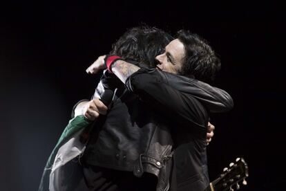 Billie Joe de Green Day abraza a uno de sus fans a quien por un momento le dio el micrófono para que cantara mientras él sostenía la bandera de México.