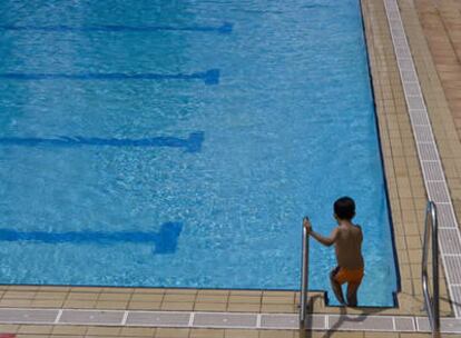Un niño se dispone a bañarse en una piscina muncipal de Madrid