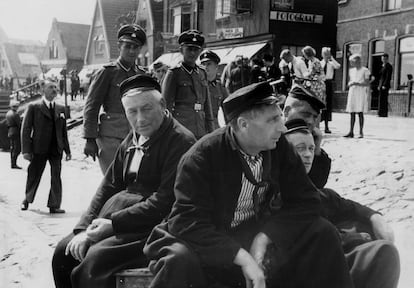 Tres soldados de las SS se pasean por una ciudad portuaria de Holanda en agosto de 1940. 