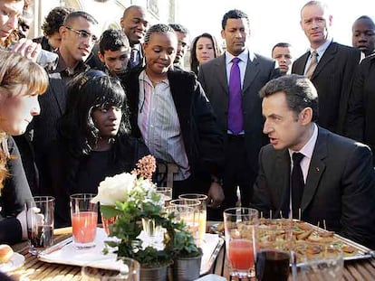 Nicolas Sarkozy charla con representantes de barrios marginales de Francia, ayer en París.