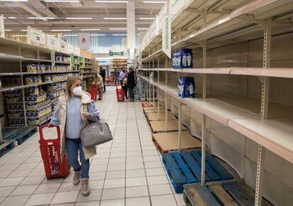 En la imagen, una mujer camina por una gran superficie en Madrid, afectada por el desabastecimiento de productos básicos. En la capital, la leche es el producto que más les cuesta encontrar a los consumidores. Si la semana pasada los cortes de suministro afectaban mayoritariamente a la lecha fresca, en los últimos días se ha extendido al resto. En el Carrefour del barrio de Ventas hay únicamente leche de almendra, de coco, de soja y avena. De vaca quedan algunas botellas de leche fresca en la nevera. “Se acaban existencias muy rápido en los almacenes y los camiones llegan a cuentagotas”, comenta un reponedor.