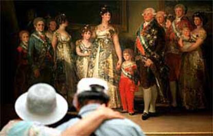 Dos visitantes contemplan <b></b><i>La familia de Carlos IV</i> de Goya, en el Museo del Prado.