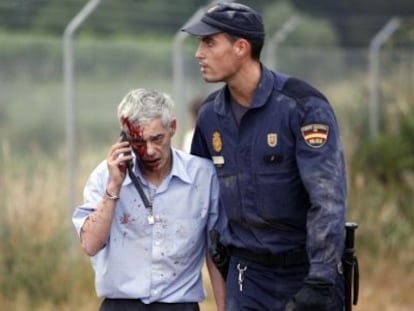 Un policía acompaña al maquinista Francisco José Garzón, poco después del accidente del tren Alvia.
