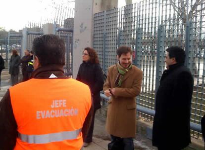 Un jefe de evacuación de un edificio cercano intenta mantener a la gente alejada del lugar