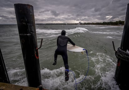 Un surfista salta a las frías y agitadas aguas del mar Báltico, en Timmendorfer Strand (norte de Alemania).