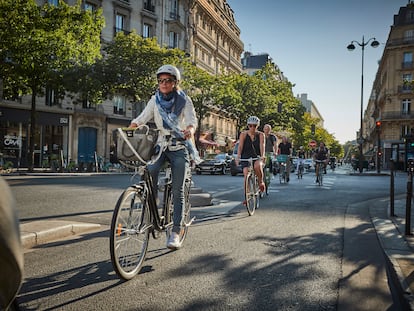 Varias personas pedalean por un carril bici de París.