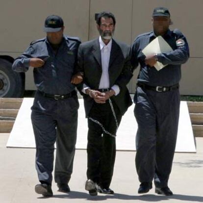 Dos agentes conducen a Sadam Husein a una base de EE UU a las afueras de Bagdad el pasado julio.
