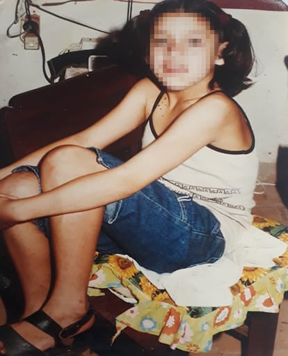 Susana, fictitious name, poses in Lucho Roma's room while he takes a photograph of her.