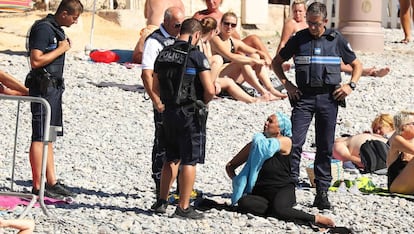 Policies a Niça obliguen una dona a treure's la roba a la platja.