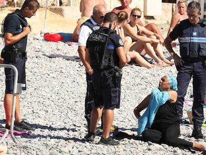 Policies a Niça obliguen una dona a treure's la roba a la platja.