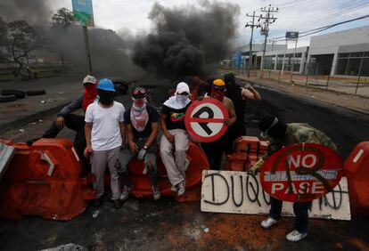 Manifestantes vigilan este lunes una barrera durante una protesta en Cali. 