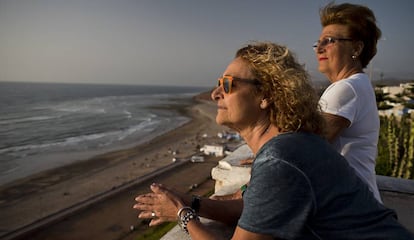 Amelia Rojas (izquierda) y Pilar Martín-Peñasco, ambas nacidas en Sidi Ifni, se asoman desde la barandilla sobre la playa.