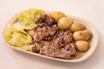 Plato del día de secretos de cerdo negro con patatas y repollo. 