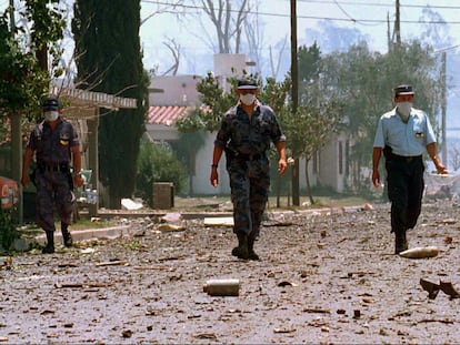 Tres policías caminan por una calle en Río Tercero (Argentina), tras la explosión en noviembre de 1995.