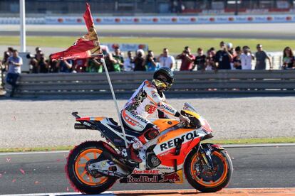 Marc Márquez celebra su título mundial en Valencia con una bandera de su club de fans con el '1'.