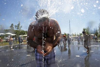 Un hombre se refresca en las fuentes de chorros a orillas de Madrid Río.