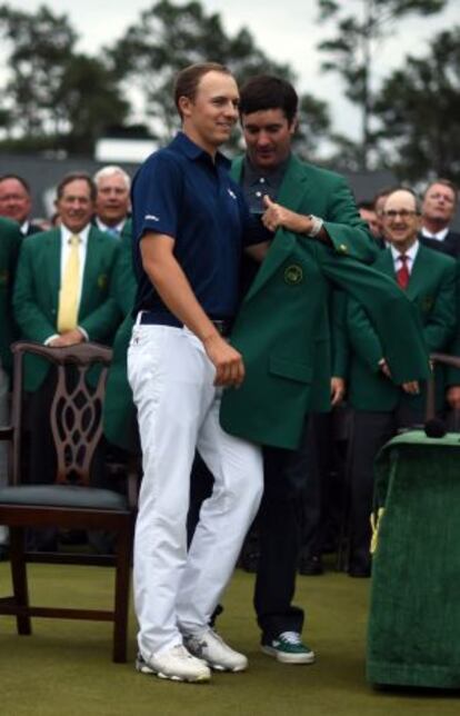 Spieth recibe la chaqueta verde de manos de Smith.