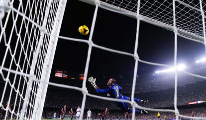 Víctor Valdés observa cómo el balón se estrella en el larguero después de un lanzamiento de Benzemá