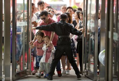 Un guardia de seguridad abre las puertas de entrada para la inauguración del Wanda Mall en Nanchang en la provincia de Jiangxi de China. 