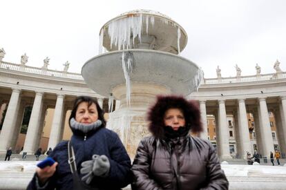 En Roma, la temperatura al mediodía de este domingo es de tan solo dos grados y, bajo un cielo cubierto, la sensación de frío es mayor por las rachas de viento. en la foto, dos mujeres sentadas en una fuente helada por las bajas temperaturas en la plaza de San Pedro, en el Vaticano, Roma.