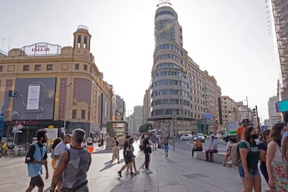 Gente paseando en la plaza de Callao y Gran Vía madrileñas.