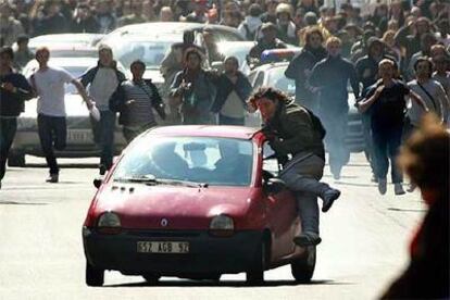 Un estudiante intenta detener un coche después de que su conductor atropellara a un grupo de manifestantes.
