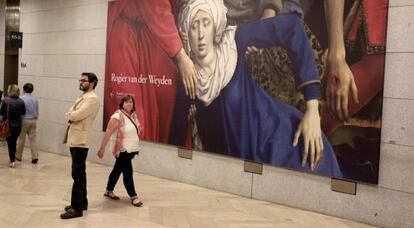 Dos espectadores junto al 'Descendimiento de la cruz' del flamenco Rogier van der Weyden, en el museo de El Prado.