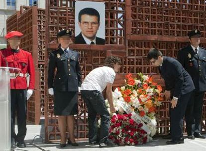 Los dos hijos del policía asesinado colocaron ayer en el Parlamento una corona de flores bajo la fotografía de su padre.