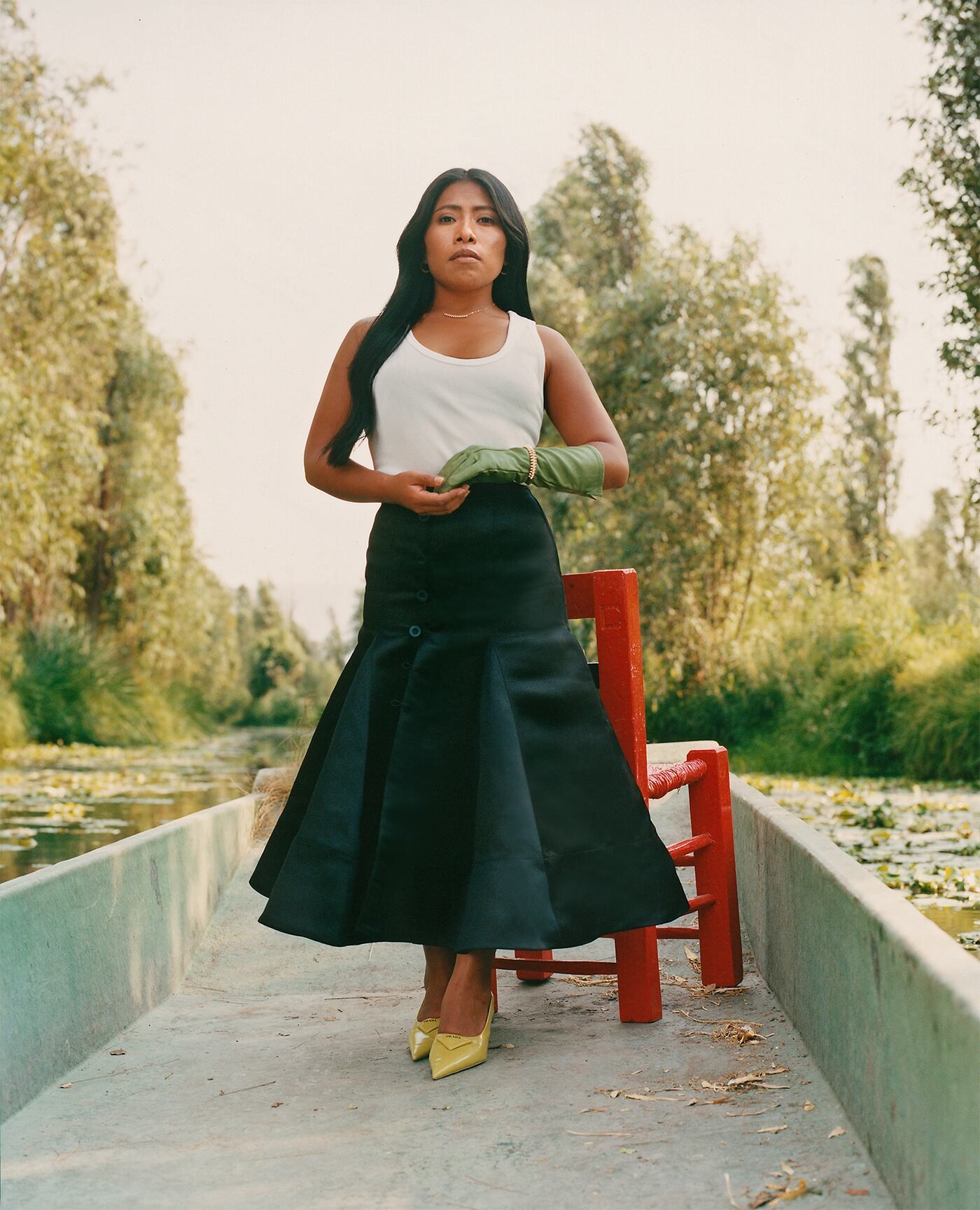 Yalitza Aparicio con top de CALVIN KLEIN, falda de ABEL LÓPEZ ATELIER, zapatos de PRADA y pendientes, collar y pulseraClash de CARTIER.