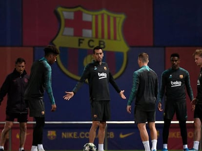 Busquets gesticula com companheiros em treino do Barcelona.