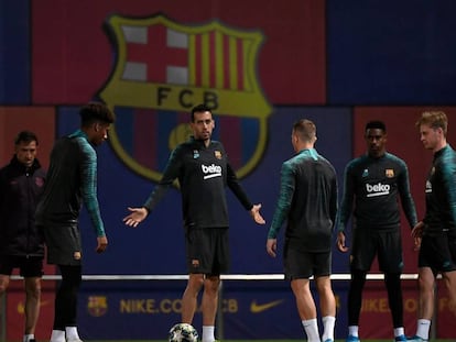 Busquets gesticula com companheiros em treino do Barcelona.