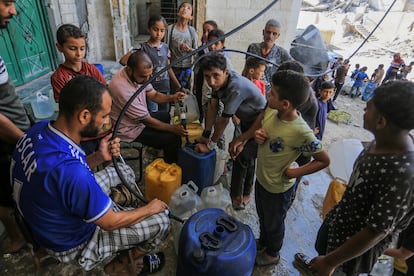 Palestinos reciben agua potable de la mezquita Al-Shafi y la llevan a sus tiendas, mientras los continuos bombardeos israelíes han destruido la infraestructura del enclave, dejando a los residentes sin acceso a agua potable en Jan Yunis, Gaza, el 16 de agosto.