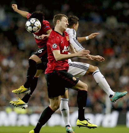 Özil lucha un balón con los jugadores del Manchester Phil Jones y Shinji Kagawa.