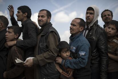 Un grupo de ciudadanos iraquíes hacen cola para recibir comida en un barrio recientemente liberado del Estado Islámico por las fuerzas iraquíes, en Mosul (Irak).