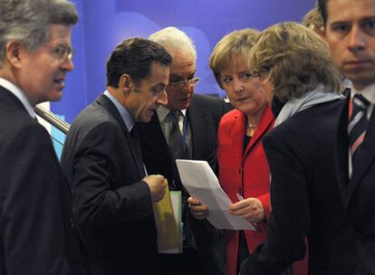 Nicolas Sarkozy (segundo por la izquierda) conversa con Angela Merkel, rodeados de sus colaboradores, durante la cumbre.