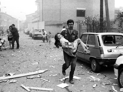 Un guardia civil lleva en brazos a una niña a la que le falta un pie, en el atentado contra la casa cuartel de la Guardia Civil en Vic (Barcelona), el 29 de mayo de 1991.