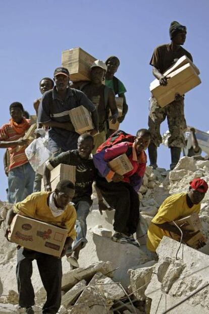 Haitianos extraen mercancías de una tienda derrumbada en Puerto Príncipe.