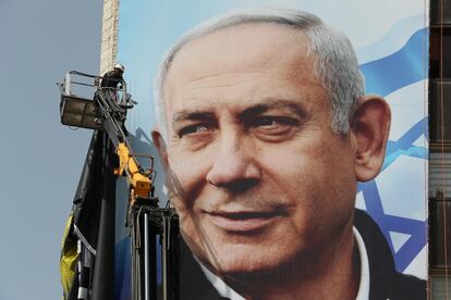 Un operario coloca un cartel electoral de Netanyahu, el miércoles en Jerusalén.