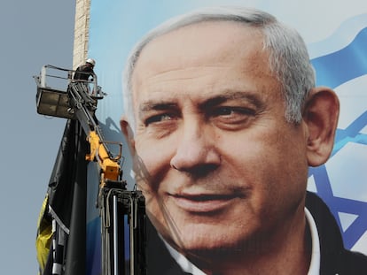Un operario coloca un cartel electoral de Netanyahu, el miércoles en Jerusalén.