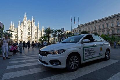 Un taxi lleva publicidad sobre el refer&eacute;ndum lombardo en la plaza del Duomo en Mil&aacute;n.