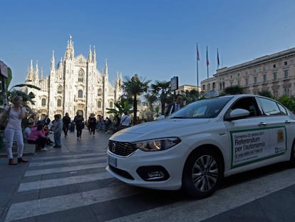 Un taxi lleva publicidad sobre el refer&eacute;ndum lombardo en la plaza del Duomo en Mil&aacute;n.